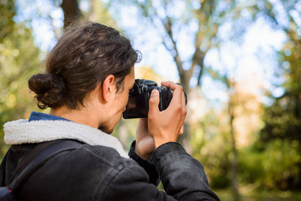 Photographer shooting pictures outdoors in the park - Fotó, kép