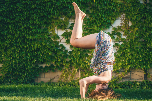 Beautiful woman practicing yoga in the garden - Фото, зображення