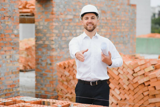 建設現場における屋根構造物の建設を管理する建設労働者. - 写真・画像