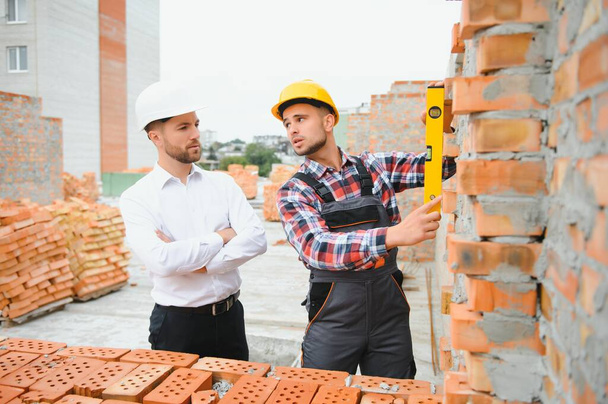 Builder and engineer on construction site. - Foto, Imagen