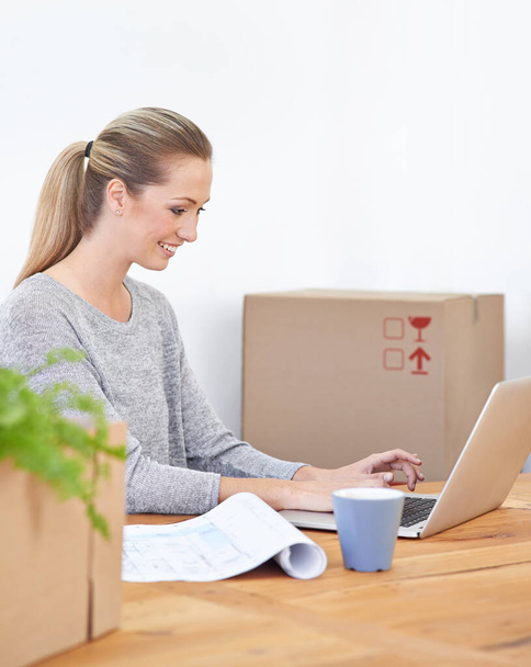 Dohonit I v den stěhování. Mladá žena sedící ve své kanceláři obklopená krabicemi - Fotografie, Obrázek