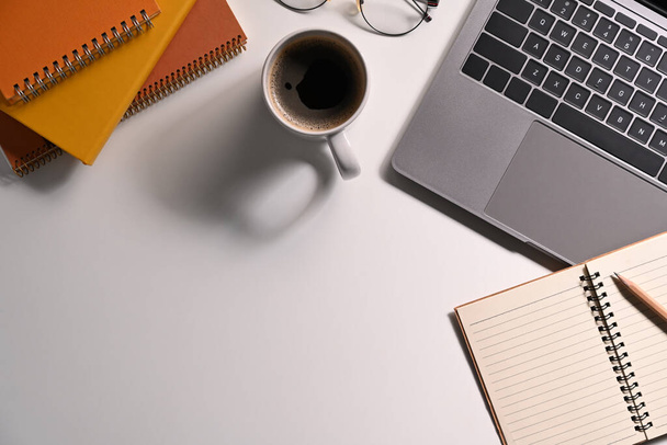 Ноутбук, ноутбуки, очки и чашка кофе на белом столе. - Фото, изображение