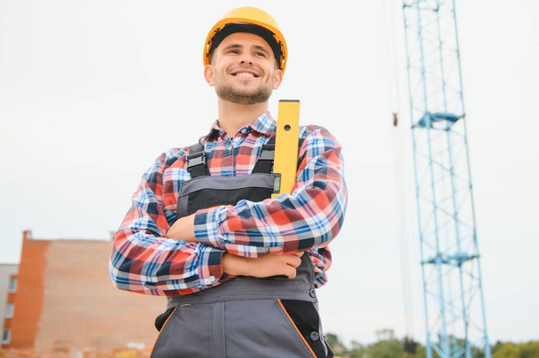 Construction worker in uniform and safety equipment have job on building. - Φωτογραφία, εικόνα