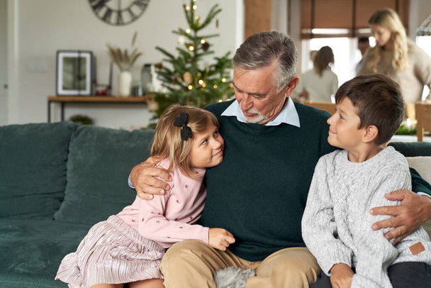Abuelo y nietos se unen en el sofá en Navidad - Foto, imagen