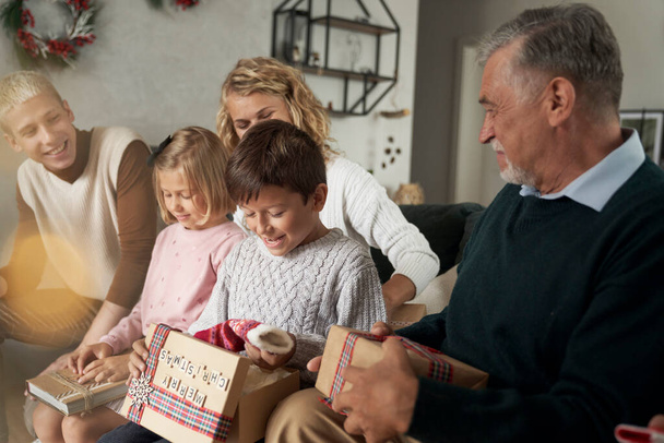 Multi pokolenie kaukaskie rodzina otwiera prezenty świąteczne i zabawy - Zdjęcie, obraz