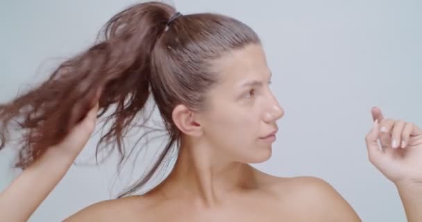 Kauneus nainen tekee poninhäntä, eristetty valkoinen - Materiaali, video