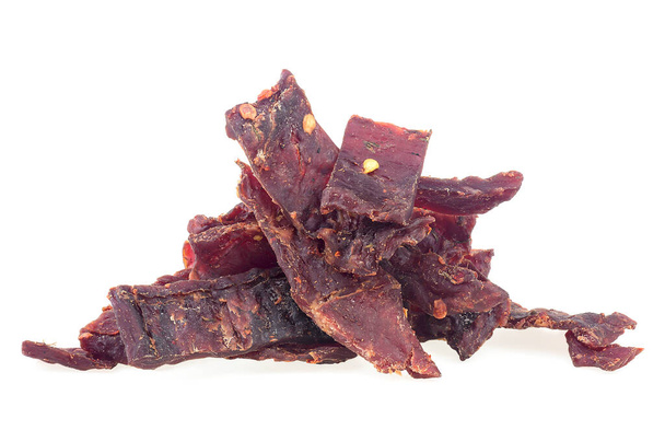 Pieces of beef jerky meat isolated on a white background. Spiced jerky meat. - Foto, immagini