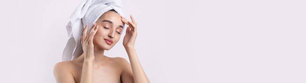 Beautiful girl with thick eyebrows and perfect skin at white background, towel on head, beauty photo. - Photo, Image