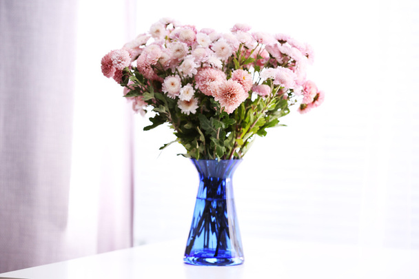 Beautiful flowers in vase with light from window - Foto, imagen