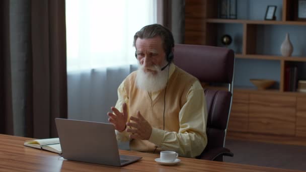 Senior ceo. Close up retrato de homem barbudo idoso conversando com colegas através de reunião virtual on-line no laptop, discutindo detalhes do projeto, sentado em casa escritório, câmera lenta, espaço vazio - Filmagem, Vídeo