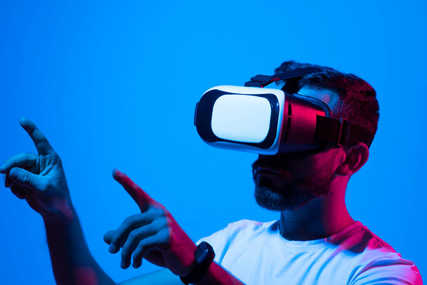 Mans portrait of bearded man wearing virtual reality glasses. Handsome caucasian male using VR headset, playing video games. Playing with VR - Foto, imagen