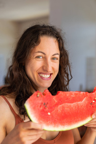 Smiling girl eating watermelon, woman holding watermelon slice, juicy watermelon season - Foto, Imagem