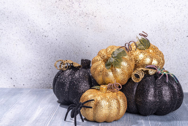 Black and cold colored pumpkins on gray wooden background. Minimalist style Halloween Thanksgiving background copy space - 写真・画像