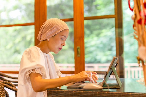 Красива азіатська жінка, що ходить на ноутбуці вдома
 - Фото, зображення