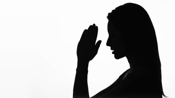 Closeup Profiel van een vrouw bidden in silhouet geïsoleerd - Video