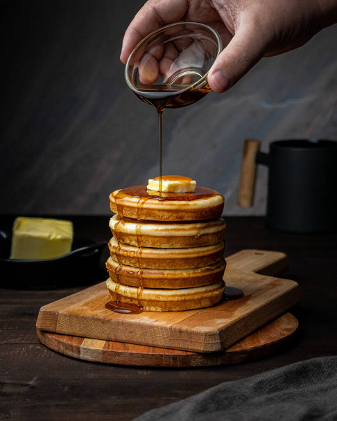 Pancake tower with one hand pouring syrup - Фото, зображення