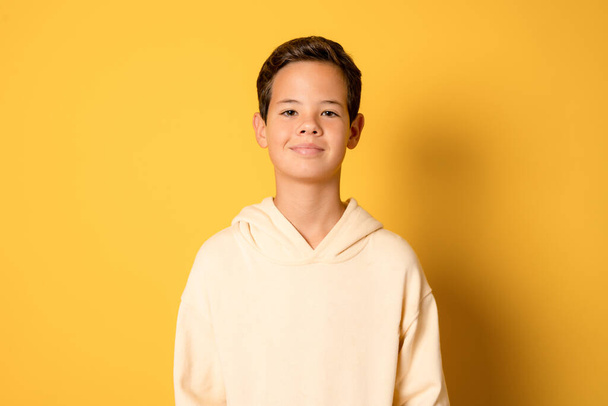 szczęśliwy młody biały chłopiec w casual strój izolowane na żółte tło - Zdjęcie, obraz