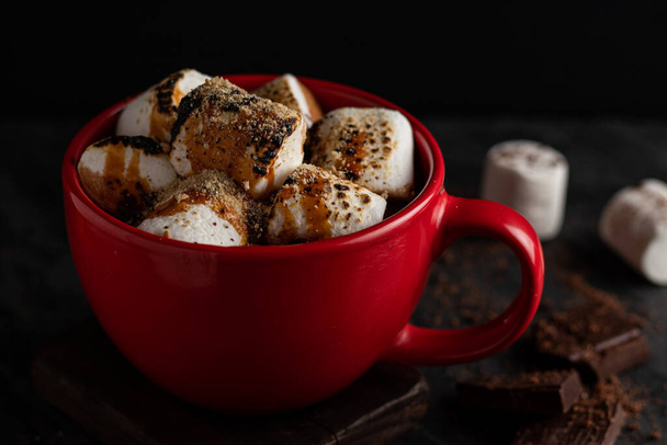 cup of hot chocolate, cinnamon sticks, cocoa beans and spices on a wooden background. selective focus. - Foto, Imagem