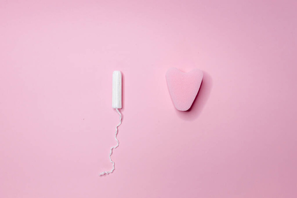 White and pink sanitary tampons lie in a row on a light pink background. Menstrual cycle and pregnancy. Negative pregnancy test and contraceptives - Fotoğraf, Görsel