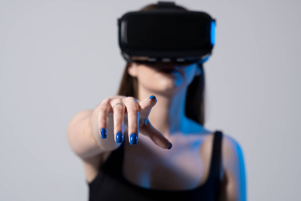 Technology, innovation gadgets. Brunette woman using virtual reality glasses.Virtual gadgets for entertainment, work, free time and study. Playing with VR - Zdjęcie, obraz
