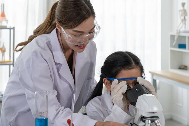 Asiatische Kinder lernen Chemie und Naturwissenschaften im Labor mit dem Lehrer - Foto, Bild