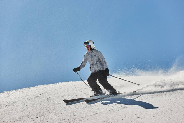 Skier sliding down a snowy slope fast - Photo, image