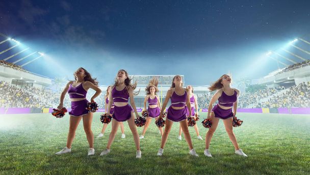 Grupa cheerleaderek w akcji na stadionie w nocy - Zdjęcie, obraz