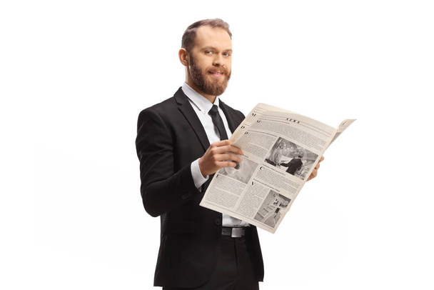 Profesionální muž v obleku stojí s novinami a usmívá se na kameru izolované na bílém pozadí - Fotografie, Obrázek