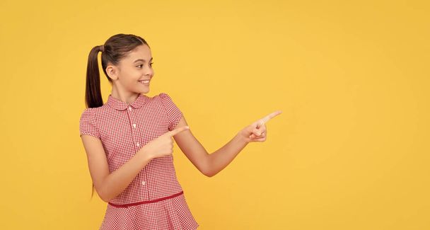 happy kid pointing finger on yellow background copy space, announcement. - Photo, Image