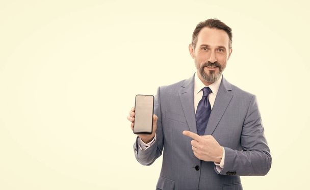 product proposal. advertisement presentation. copy space. grizzled man pointing finger on phone screen. mature businessman showing smartphone isolated on white. man in businesslike suit. new app. - Photo, image