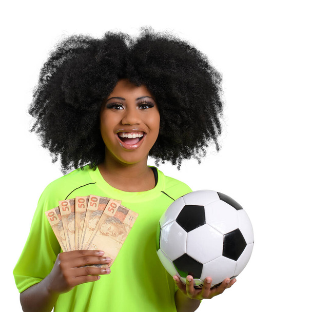Nainen jolla brasilialainen raha on jalkapallo pallo pallo, hän pukeutuu neon vihreä uniformon valkoinen tausta - Valokuva, kuva