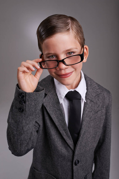 Hes a great dresse. Studio shot of a cute young boy wearing a retro suit against a grey background - Foto, Imagem