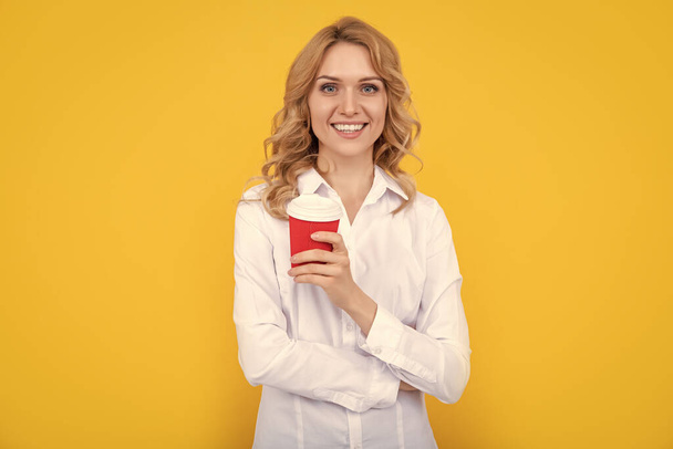 mujer rubia feliz con taza de café de la mañana sobre fondo amarillo. - Foto, Imagen