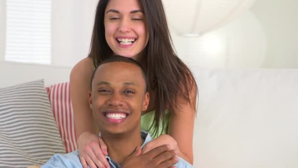 Schwarzer Mann lächelt, während Freundin lustige Gesichter macht und die Zunge herausstreckt - Filmmaterial, Video