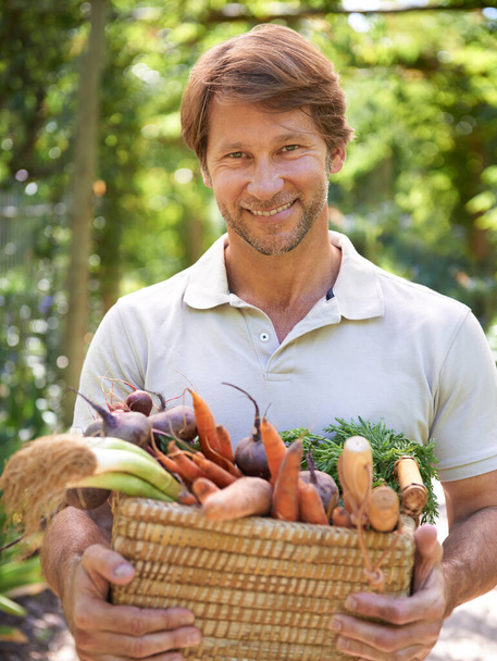 Isso mesmo, é totalmente orgânico. Um homem maduro segurando uma cesta de legumes frescos - Foto, Imagem