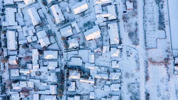 上からの眺めは、雪に覆われた民家の屋根、冬の街並。.   - 写真・画像