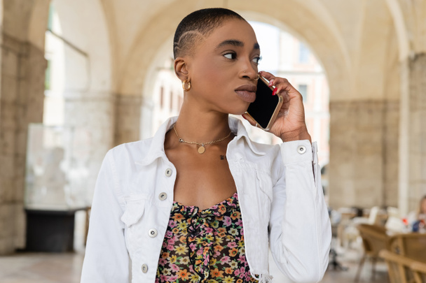Stilvolle afrikanisch-amerikanische Touristin telefoniert auf urbaner Straße in Treviso - Foto, Bild