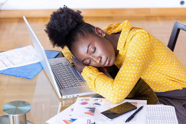Unavená, přepracovaná žena odpočívala, když pracovala na psaní poznámek. Přepracovaná a unavená žena spí u laptopu ve stole doma. Unavená žena - Fotografie, Obrázek