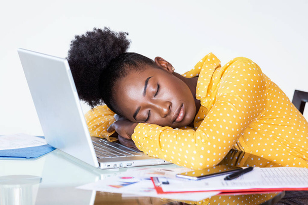 Fatiguée, la femme surmenée se repose pendant qu'elle écrit des notes. Femme d'affaires surmenée et fatiguée dormant sur un ordinateur portable dans un bureau à la maison. Femme d'affaires fatiguée
 - Photo, image