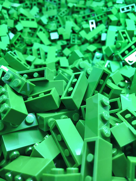 Groene bouwwerken van dichtbij. Heldere kunststof constructor stukken netjes accommodatie in box container voor opslag. - Foto, afbeelding