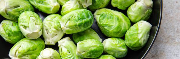 ブリュッセルはテーブルの上に緑の生の野菜の健康的な食事の軽食の食事療法を芽コピースペースの食べ物の背景素朴なトップビューケトやパレオの食事の野菜のビーガンやベジタリアン料理 - 写真・画像