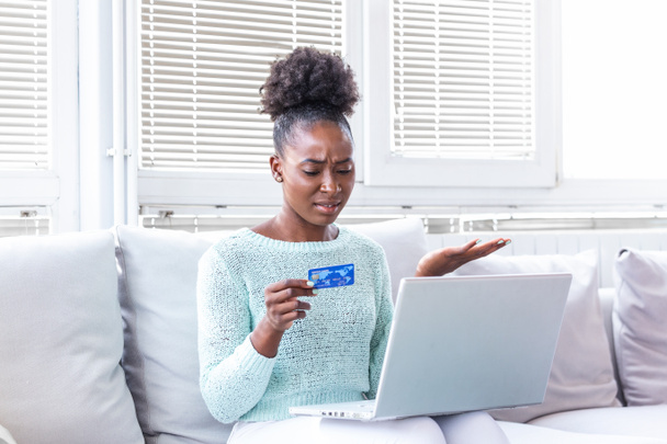 verwirrte junge Frau, die ein Problem mit blockierter Kreditkarte hat, lehnt unsichere Online-Zahlung mit Laptop zu Hause ab, ungültiges abgelaufenes Konto, fehlgeschlagene Transaktion, Geldabheben unmöglich, Schulden - Foto, Bild