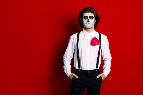 Portrait of his he handsome content creepy guy formal wear holding hands in pockets copy space corporate theme event Santa Muerte isolated bright vivid shine vibrant red color background. - Foto, imagen