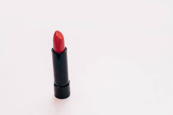Red cosmetic women's lipstick on a white background. - Фото, изображение