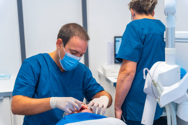 Dental clinic, dentist doctor and assistant examining the teeth of an elderly woman lying on the table - Φωτογραφία, εικόνα