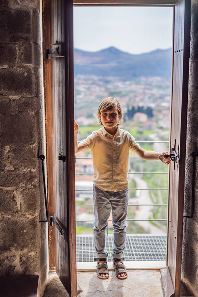 少年観光客はモンテネグロの旧市街を歩く。幸せな観光客が山の中を歩く。バルカンのモンテネグロ、バーの街の郊外。美しい自然と風景. - 写真・画像