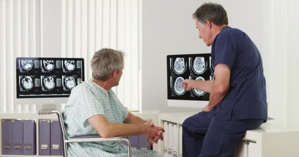 Volwassen arts legt röntgenfoto 's aan gehandicapte oudere patiënt - Video
