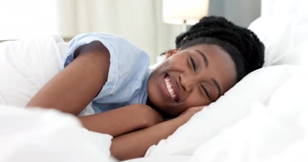 Camera da letto svegliarsi, donna nera ritratto e felice mattina dopo aver dormito su comodo cuscino morbido per un sano riposo, pisolino e pausa. Volto di sorriso giovane donna africana a letto per una tranquilla calma rilassante. - Filmati, video