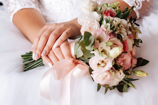 Brides fees. Bouquet of the bride in her hands before the ceremony. High quality photo - Фото, зображення