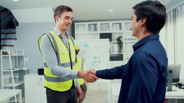 Competent businessman and engineer shake hands after successfully concluding a trading arrangement or business meeting. - Séquence, vidéo